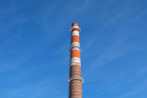 老工厂条纹，橙色，棕色，烟囱在蓝色天空的背景图片下载
