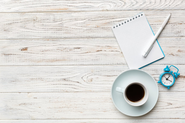 现代办公桌椅，桌上备有笔记本等用品，配有咖啡杯。空白笔记本页为您设计。俯视图，平躺图片下载