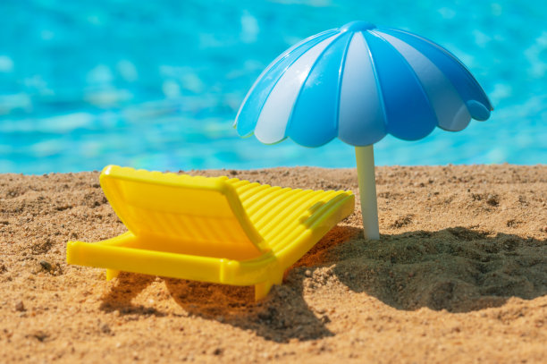 沙滩上的黄色太阳伞和一把伞图片下载