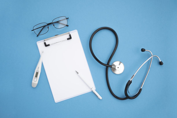 俯视图，蓝色背景的医疗配件。木制记事本，黑色听诊器，温度计，眼镜，白笔。平坦的躺,模型图片下载