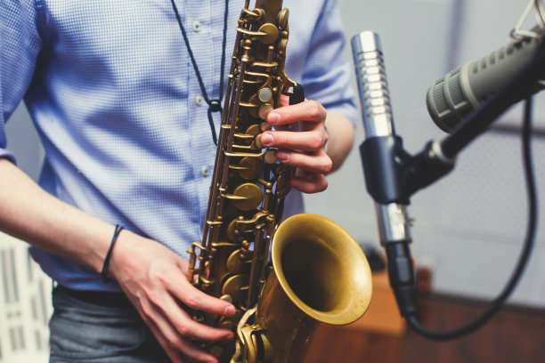 一名萨克斯管演奏者，萨克斯管演奏者与声乐家和乐手在舞台上演奏爵士乐图片下载