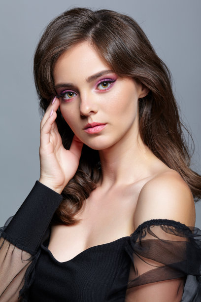 年轻女子的美丽肖像。深色皮肤的女孩与晚间女性化妆和黑色的衣服图片下载