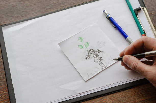 一位成年男子用绿色的气球在纸上画了一个女孩。图片下载