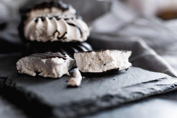 黑巧克力色的白色棉花糖放在黑色石板和灰色布料做成的架子上，是一盘甜点，减肥美味的食物图片下载