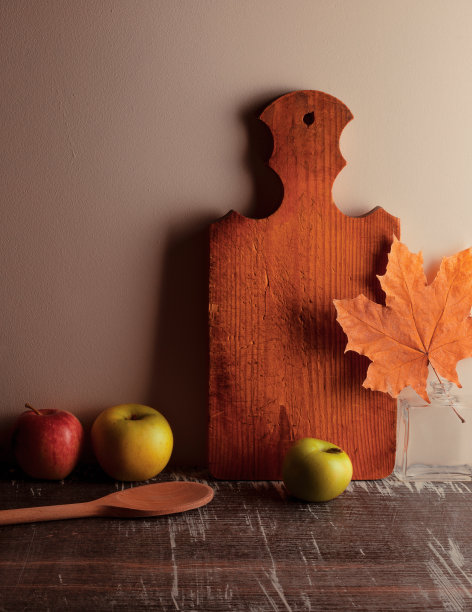 秋天安排概念照片壁纸或背景与苹果，枫叶，厨房板，木勺在木制复古桌子。图片下载