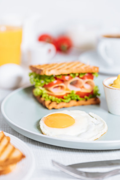 白色背景的吐司三明治，配以番茄或生菜等食材图片下载
