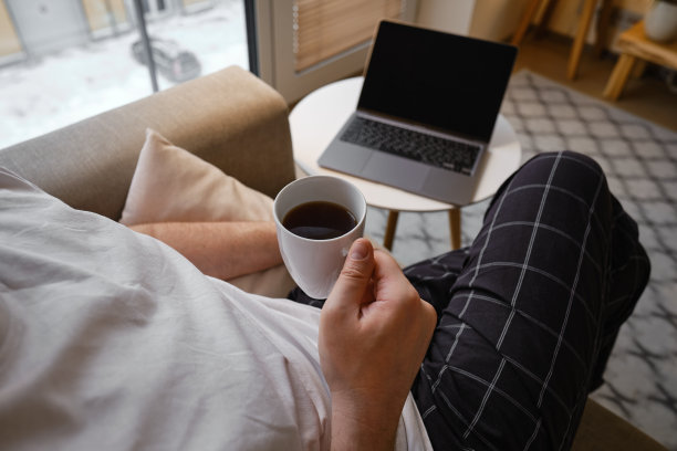 一个男人在桌子旁用笔记本电脑工作。在家远程工作。在办公室工作的商人。商业背景。家庭办公室图片下载