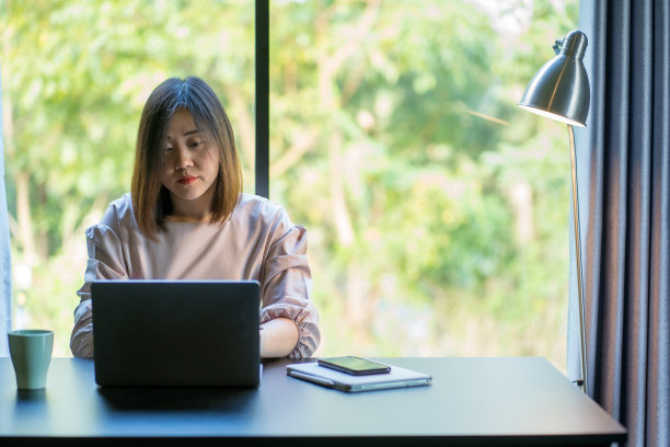 亚洲妇女微笑和快乐的在线会议和工作在客厅图片下载