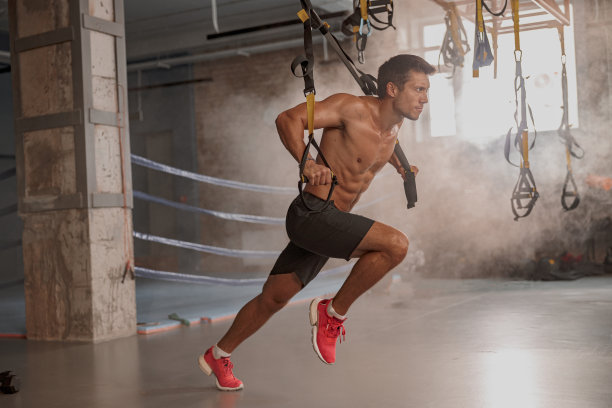 英俊的男性私人教练在健身房工作图片下载