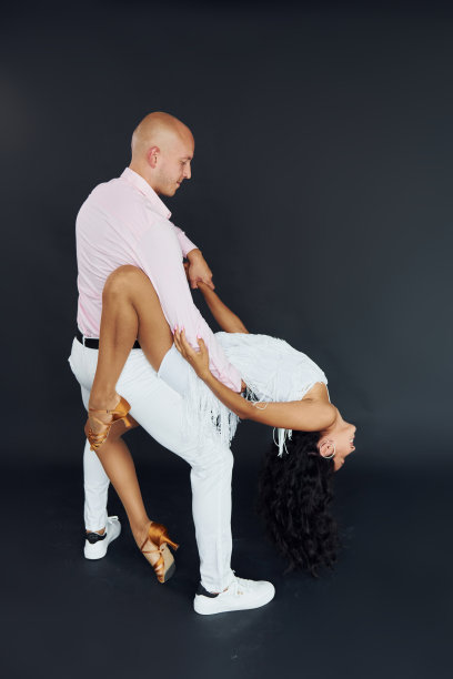 在黑色背景下跳舞。喜气洋洋的一对在室内图片下载