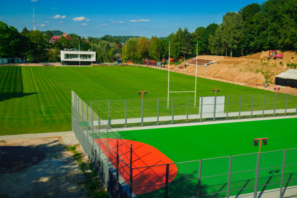 足球场或橄榄球基础设施与充满活力的绿色草地和大门，郊区的城市空间，阳光明媚的夏日晴天照片图片下载