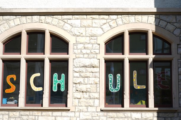 从外面可以看到两扇窗户，上面用德语写着学校。图片下载