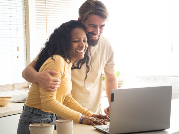 年轻的异性恋多民族夫妇在厨房里视频通话图片下载