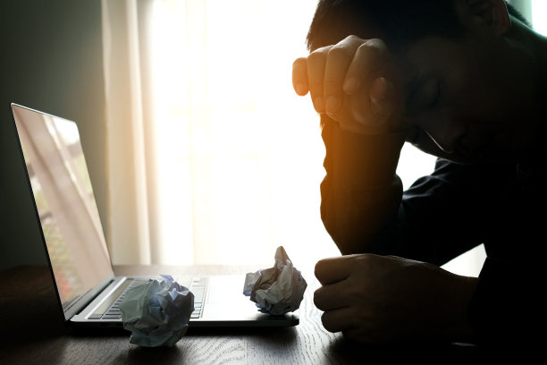 那人坐了下来，脸上露出不安的神色。在电脑桌前，她感到头痛和压力。原因是工作繁重，休息不足。图片下载