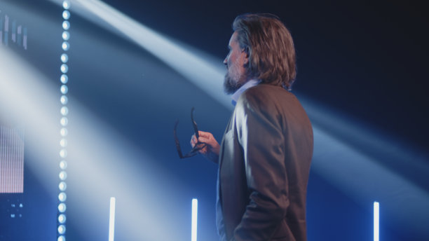 严肃的商业教练看着LED屏幕上的图表图片下载