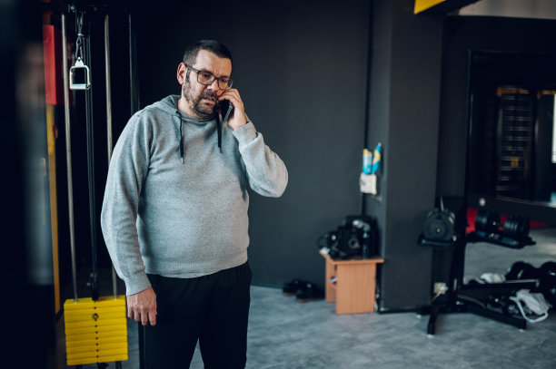 男子使用智能手机，在健身房训练时休息图片下载