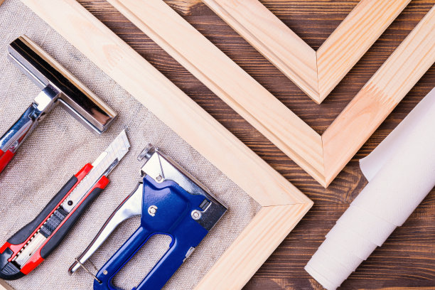 在画布上打印照片。组织在木制担架上伸展帆布的业务的设备和工具。图片下载