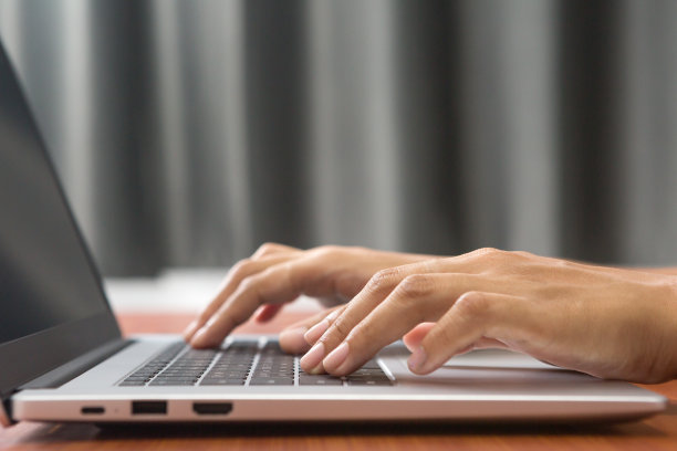 使用手提电脑对女性手部进行选择性聚焦。图片下载