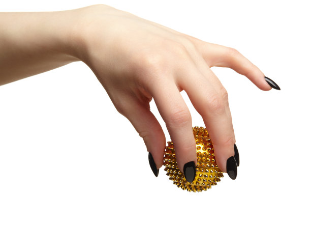 女性手部有黑色的指甲和指甲，手指上有金色的按摩球。图片下载