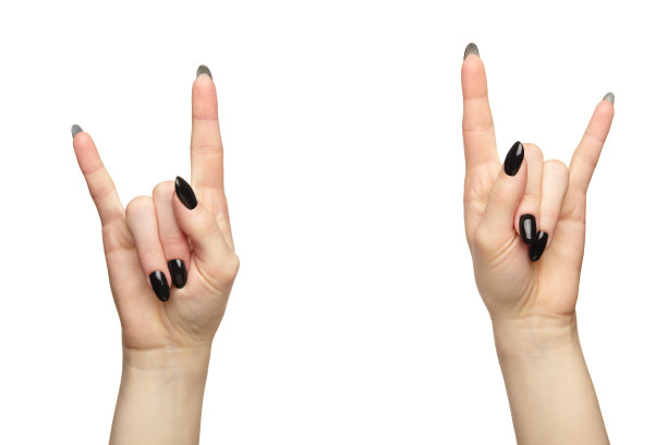 女性的手与黑色指甲指甲孤立在白色背景。手指摆成胜利的手势。图片下载