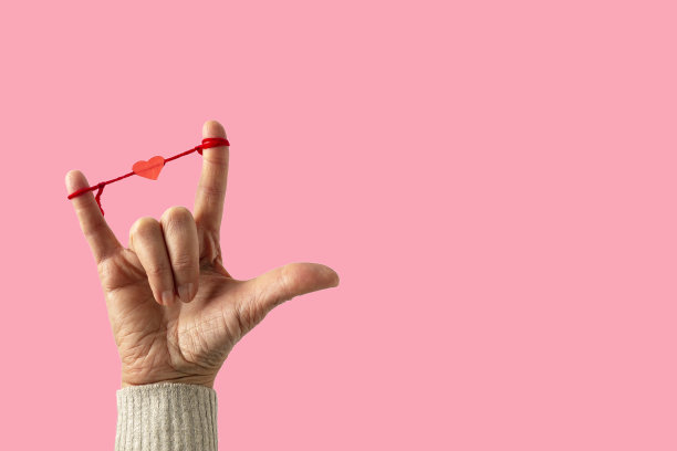 手语里的I-Love-You，聋哑人的语言。女人的手放在粉色的背景上，复制空间。图片下载