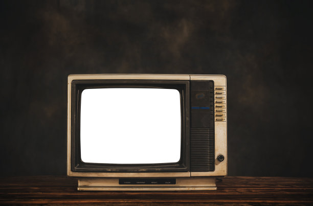 复古的老电视在木桌上与黑暗的墙壁背景，剪出白色的屏幕，静物电视图片下载