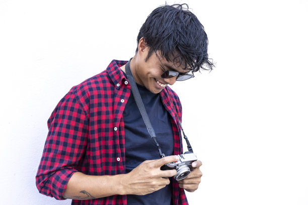 快乐嬉皮士亚洲人用老式相机站在白墙上-东方摄影师有乐趣旅行的世界-快乐的青年生活理念图片下载