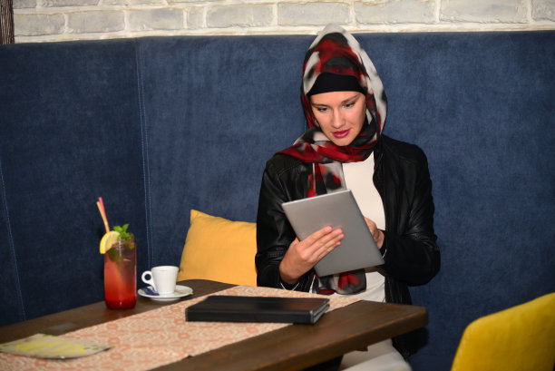 一位年轻的穆斯林妇女在café网站上工作。图片下载