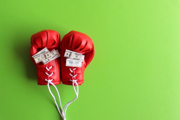 红色拳击手套和一叠钞票。运动要钱。图片下载