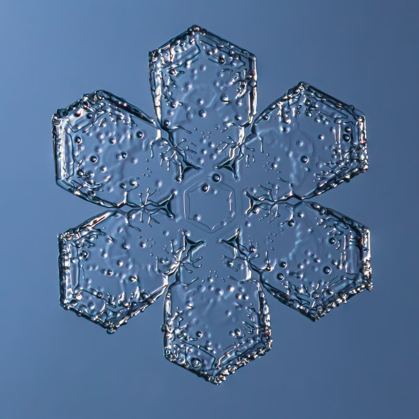 雪花在平滑梯度的背景。微距照片真实雪晶体在玻璃表面。这是一朵小花，花纹奇特。图片下载