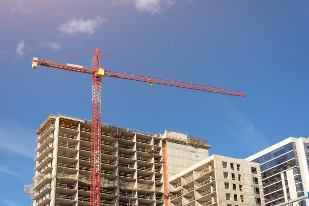 俯瞰一座有着高架建筑起重机的建筑，附近还有一座玻璃塔，里面建有房屋。图片下载