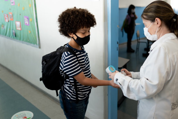 老师在进教室前给学生量体温——使用口罩图片下载