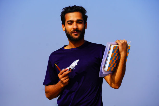 微笑的年轻大学生的肖像书和背包图片下载