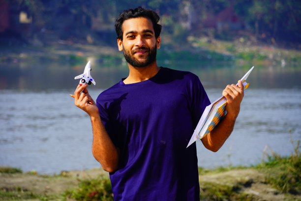 微笑的年轻大学生的肖像书和背包图片下载