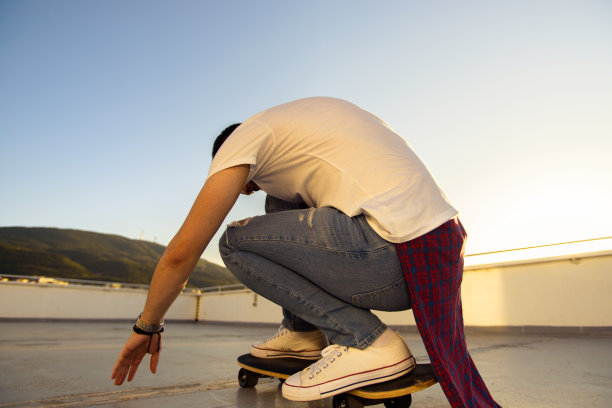 阳光明媚的一天，活跃的青少年在阳台上玩滑板的特写照片图片下载