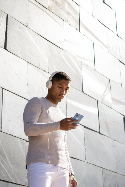 男人喜欢用手机戴着耳机听音乐图片下载