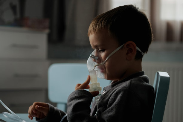小男孩在家中接受吸入治疗时使用喷雾器图片下载