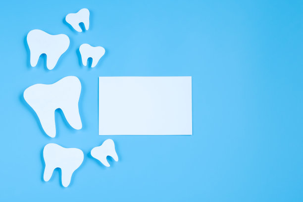 在蓝色背景上剪纸牙齿模型。牙科保健的概念。国际牙科医生的一天。图片下载