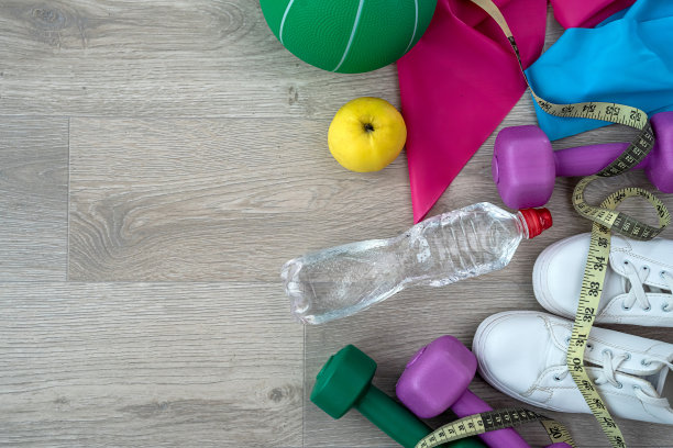 女子运动彩色哑铃和橡皮筋健身俯视图。图片下载