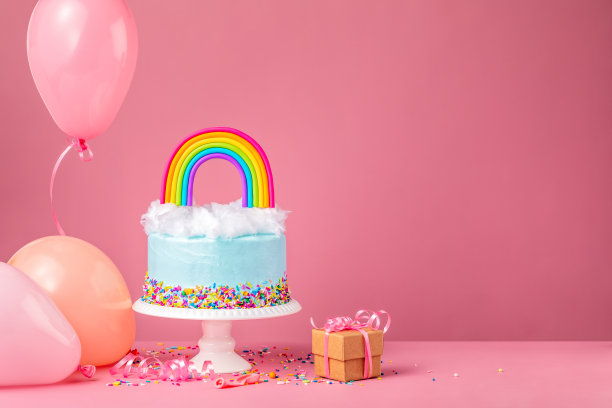 蓝色生日蛋糕上有派对气球和粉色的礼物图片下载