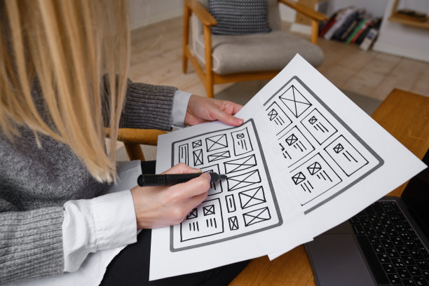 女设计师创建网站设计线框。草图，原型，框架，布局未来设计项目。UI和UX -用户界面，用户体验设计师。网页设计工作室的创意概念图片下载