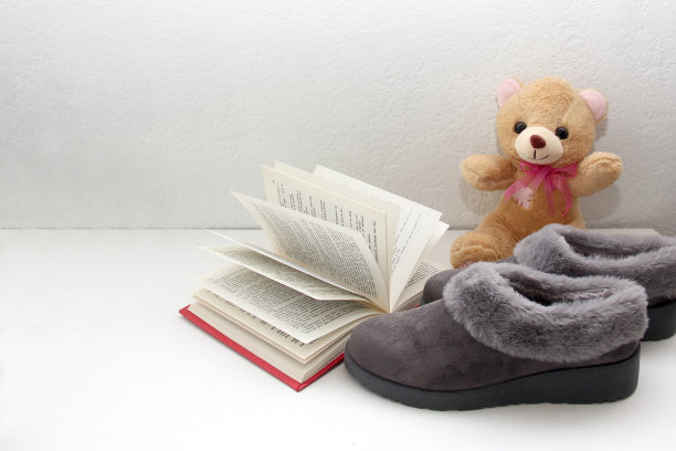 舒适的，毛绒的，有软垫的灰色拖鞋准备睡觉，懒洋洋的，放松的书，咖啡，和在床上的眼镜图片下载