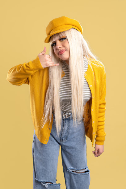 一个戴着帽子，穿着黄色夹克的金发女人斜靠在摄像机前，告诉我们一个秘密，黄色的背景图片下载