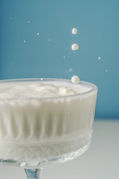 牛奶倒进一个美丽的蓝色水晶玻璃里，溅得到处都是。图片下载