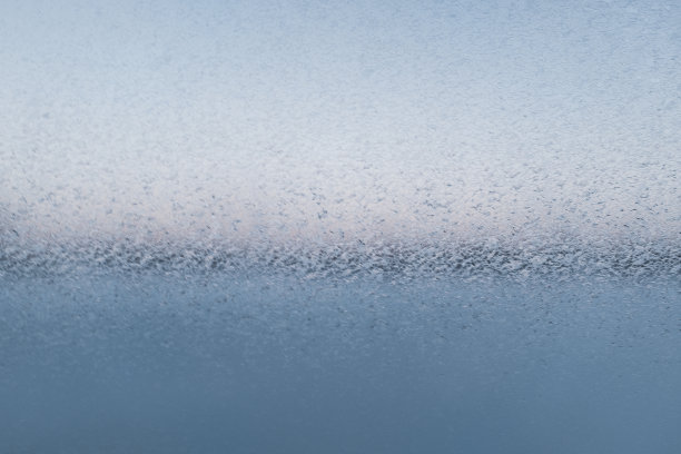 玻璃上的雪花图案，特写镜头。在寒冷的冬日画出的花式图案。窗户玻璃上的冰晶形成霜状纹理。为您的设计或文本留出空间。高质量的照片图片下载