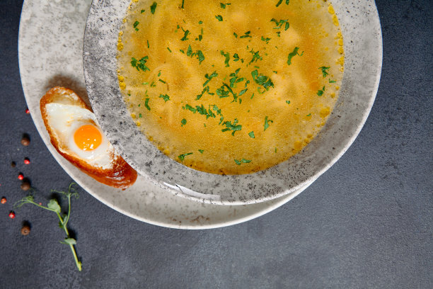 传统的碗食品-鸡肉面汤在黑暗的桌子上。汤在陶瓷碗上深色纹理背景与食品配料。图片下载