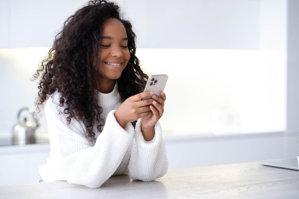 非裔美国女孩用iPhone 12智能手机按手指，阅读社交媒体网络，打字或在线购物，用两只黑人的手机13.12.21俄罗斯圣彼得堡图片下载