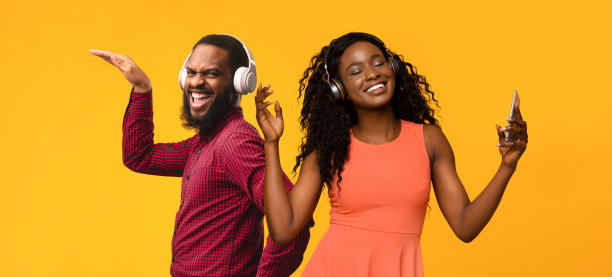 积极的黑色夫妇与无线耳机有乐趣的黄色图片下载