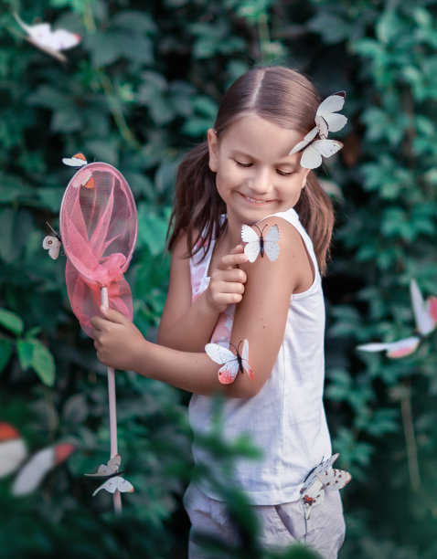 夏天女孩在花园里用网捉蝴蝶图片下载