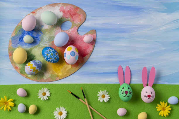 在蓝色水彩上用复活节兔子刷子和调色板画复活节彩蛋图片下载